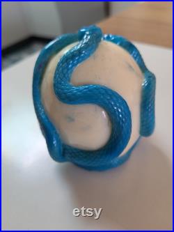 Une tête de mort avec un serpent qui sort de son orbite en s'enroulant autour de son crâne Une tête de mort avec un serpent qui sort de son orbite en s'enroulant autour de son crâne